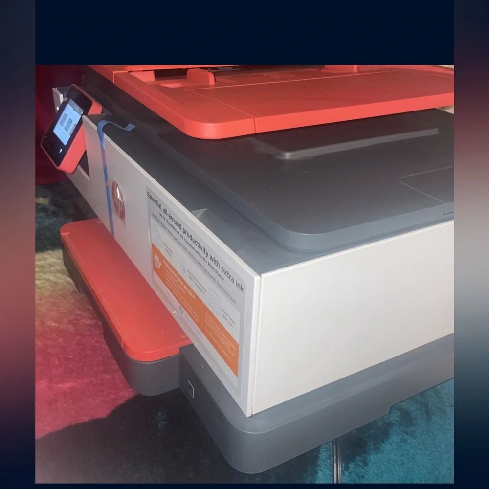 Red and white HP Printer . It’s brand new comes with paper and everything .